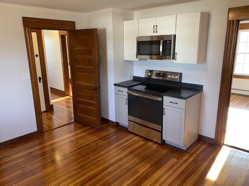 82 Comins Road, Unit 2 Hadley, MA 01035 - Photo 7 of 12 a kitchen with granite countertop a stove and a refrigerator