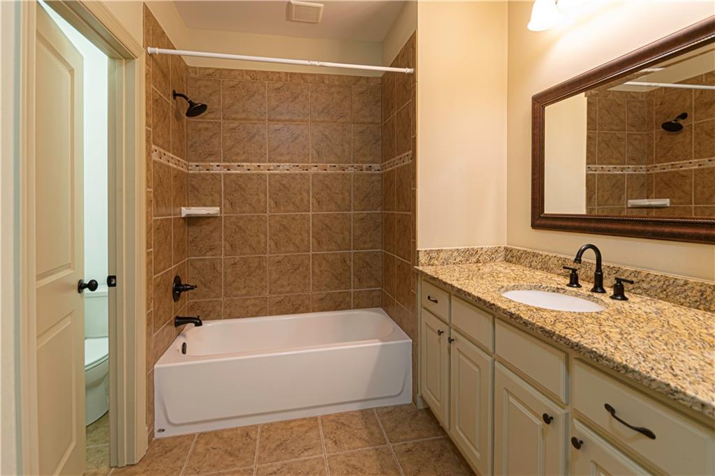 2050 Oak Grove Road Northeast Atlanta, GA 30345 - Photo 7 of 12 a bathroom with a granite countertop bathtub shower vanity and a sink