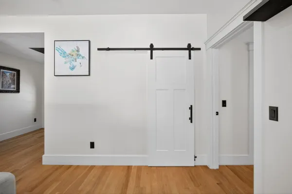a bed sitting in a bedroom next to a window and a chandelier
