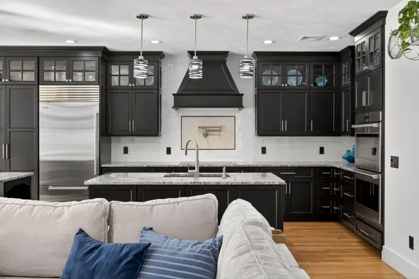 a kitchen with stainless steel appliances granite countertop a sink a stove and cabinets