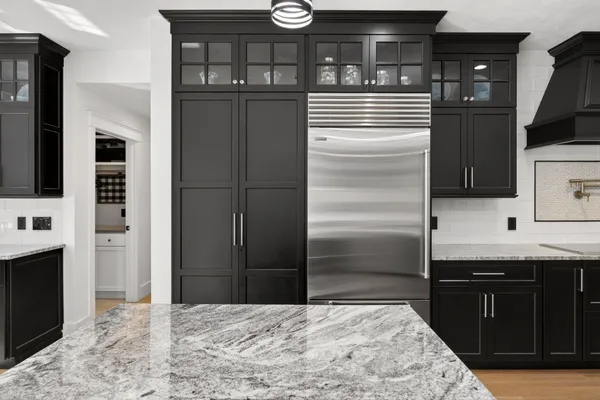 a kitchen with stainless steel appliances kitchen island a refrigerator sink and cabinets