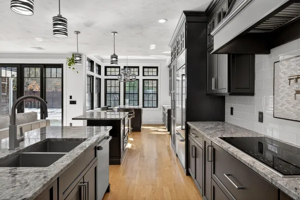 a kitchen with granite countertop a sink a counter space appliances and cabinets