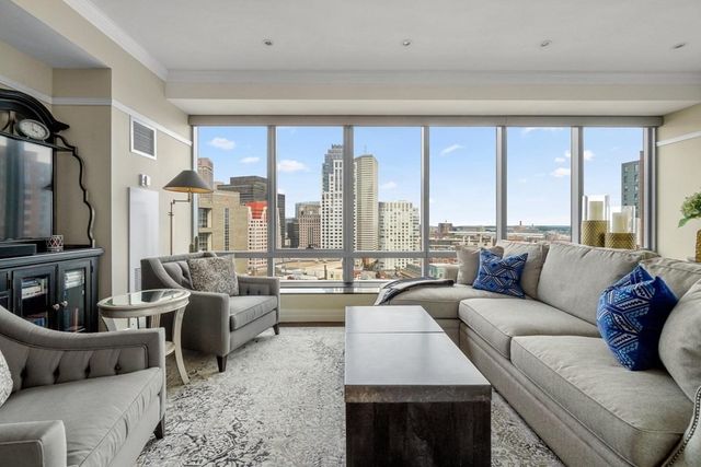 a living room with furniture large windows and a fireplace