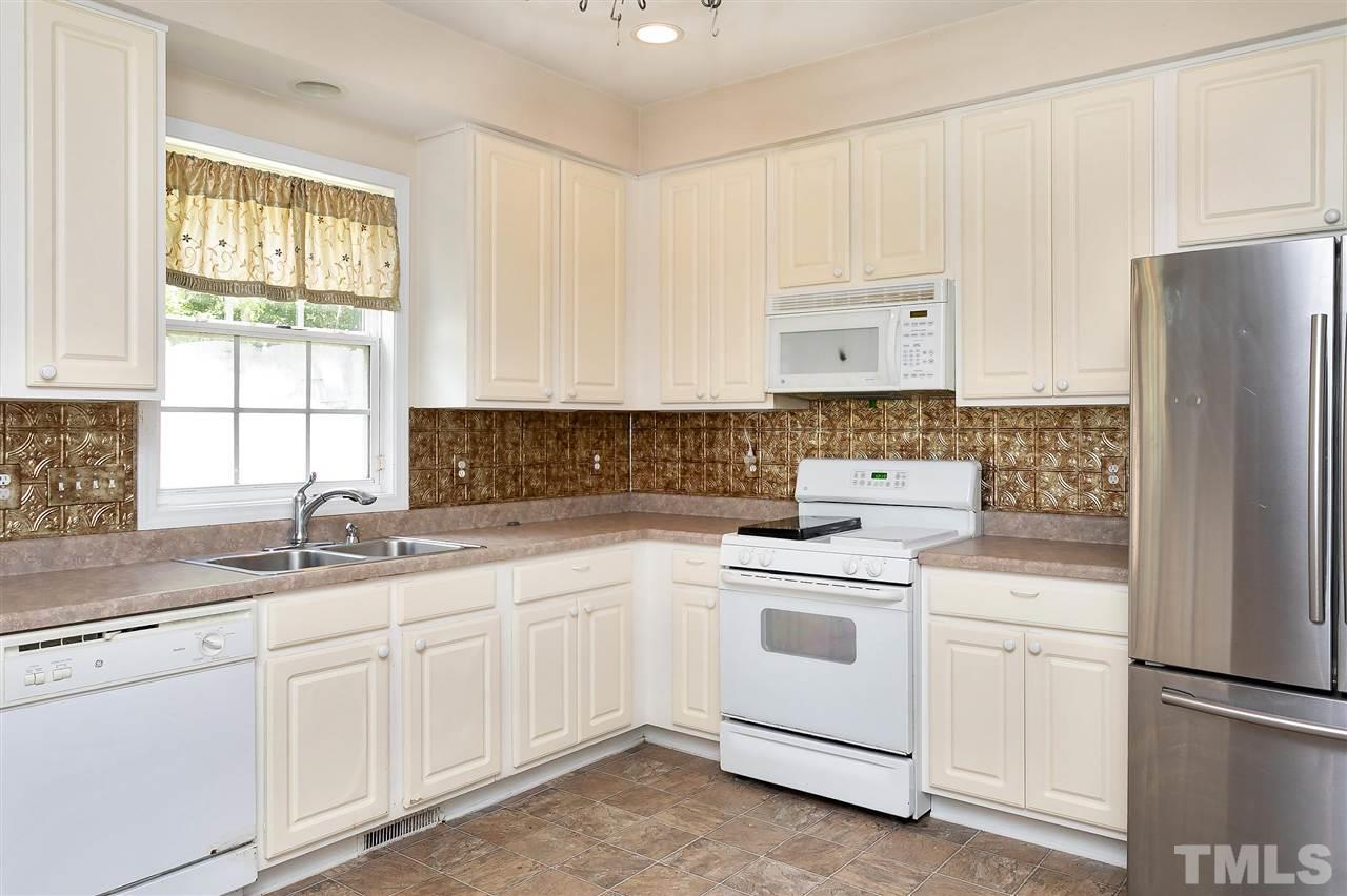 220 Mickleson Ridge Drive Raleigh, NC 27603 - Photo 20 of 20 a kitchen with white cabinets and white appliances