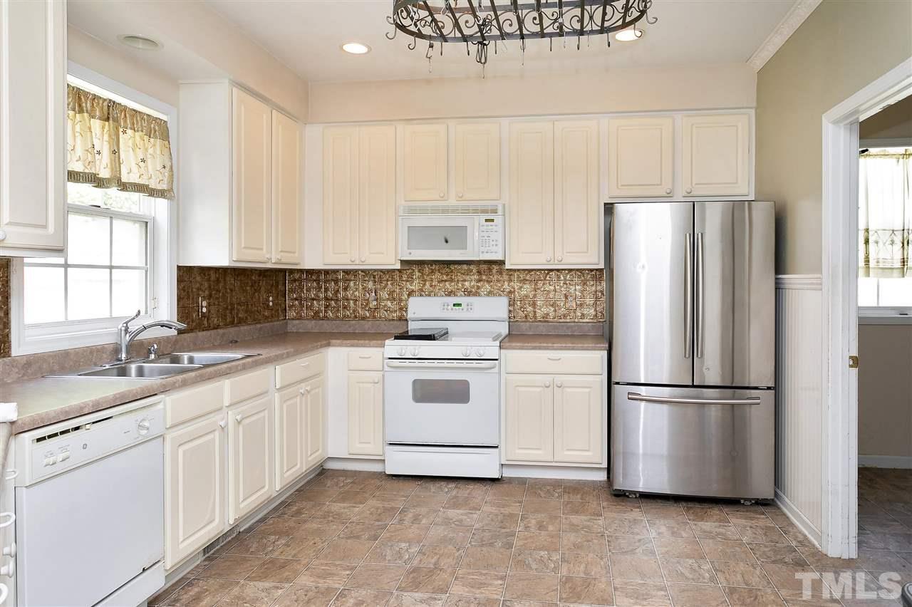 220 Mickleson Ridge Drive Raleigh, NC 27603 - Photo 5 of 20 a kitchen with a refrigerator sink and cabinets