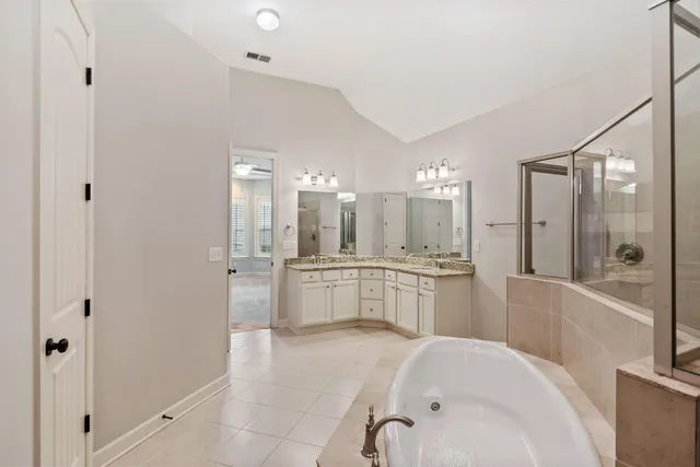 a large white bathroom with a bathtub and a shower