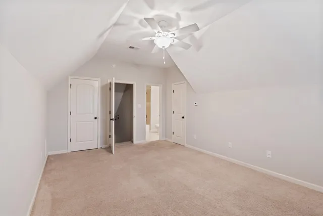 an empty room with chandelier fan and closet area