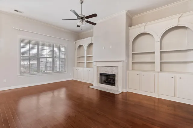 a view of empty room with wooden floor and fireplace