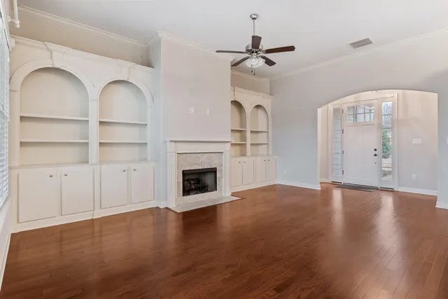 a view of empty room with wooden floor and fireplace