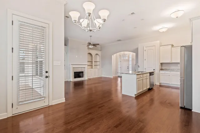 a large kitchen with cabinets wooden floor and stainless steel appliances