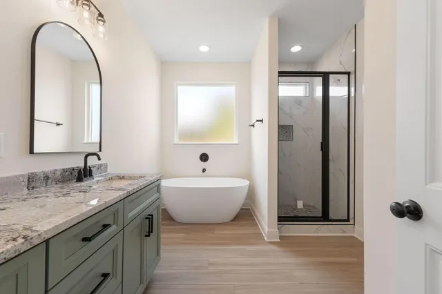 a spacious bathroom with a granite countertop sink and a mirror