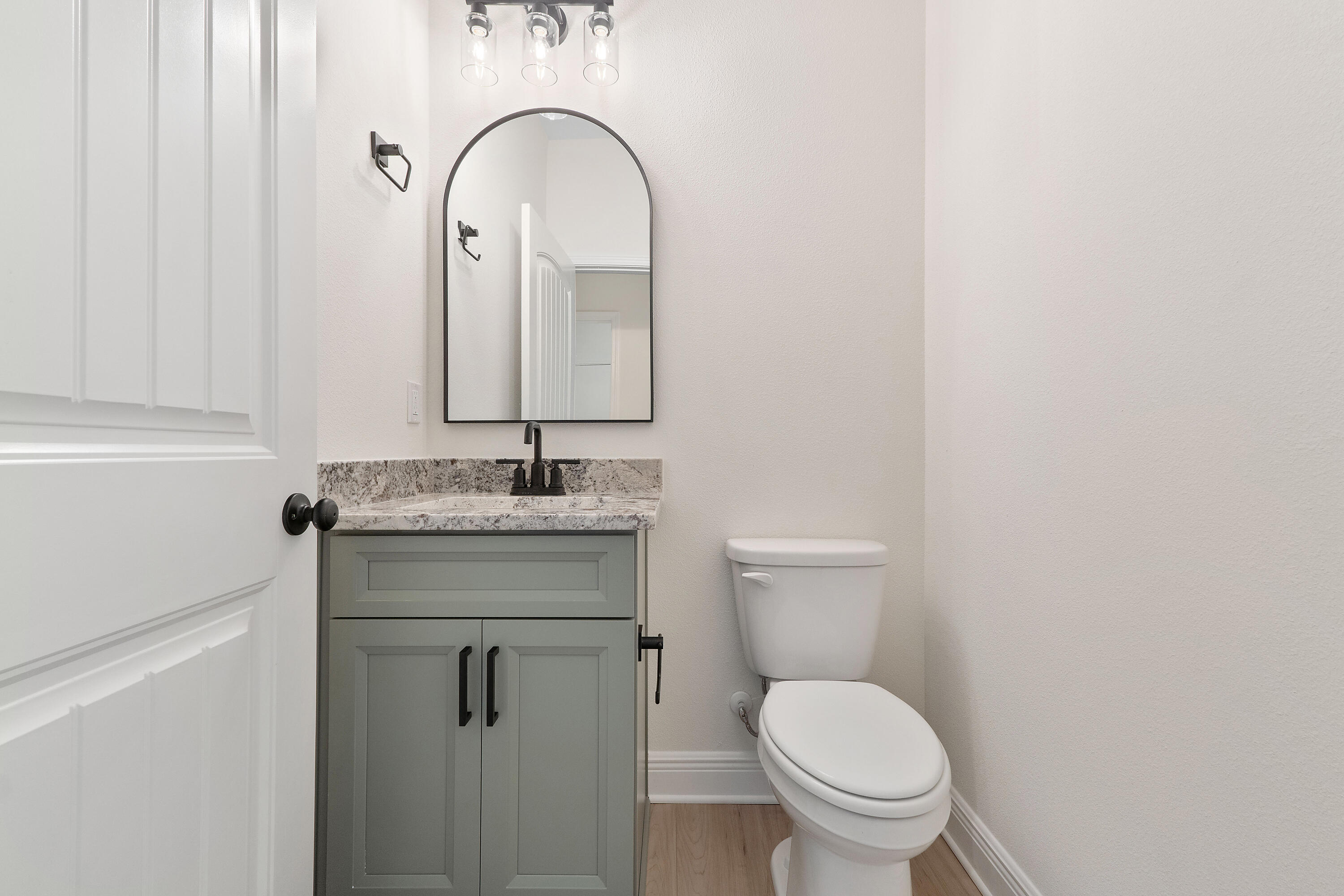 8370 Sevilla Street Navarre, FL 32566 - Photo 5 of 12 a bathroom with a granite countertop toilet a sink and a mirror