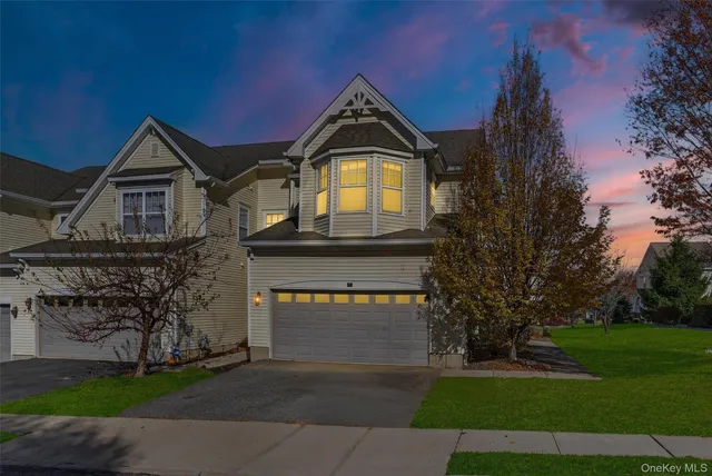 a front view of a house with a garden and trees