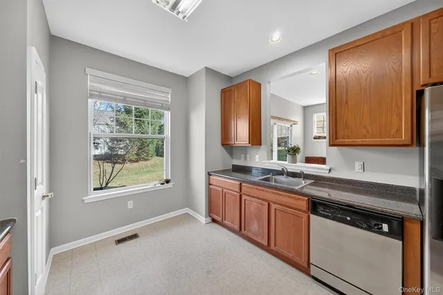 a kitchen with stainless steel appliances granite countertop white cabinets and window