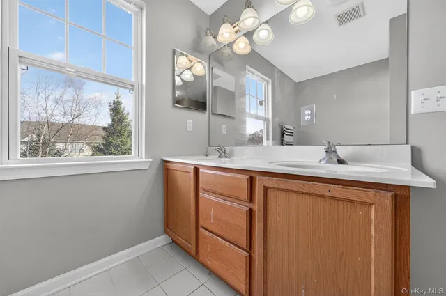 a bathroom with a double vanity sink and a mirror