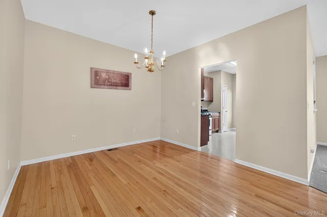 a view of empty room with wooden floor and ceiling fan