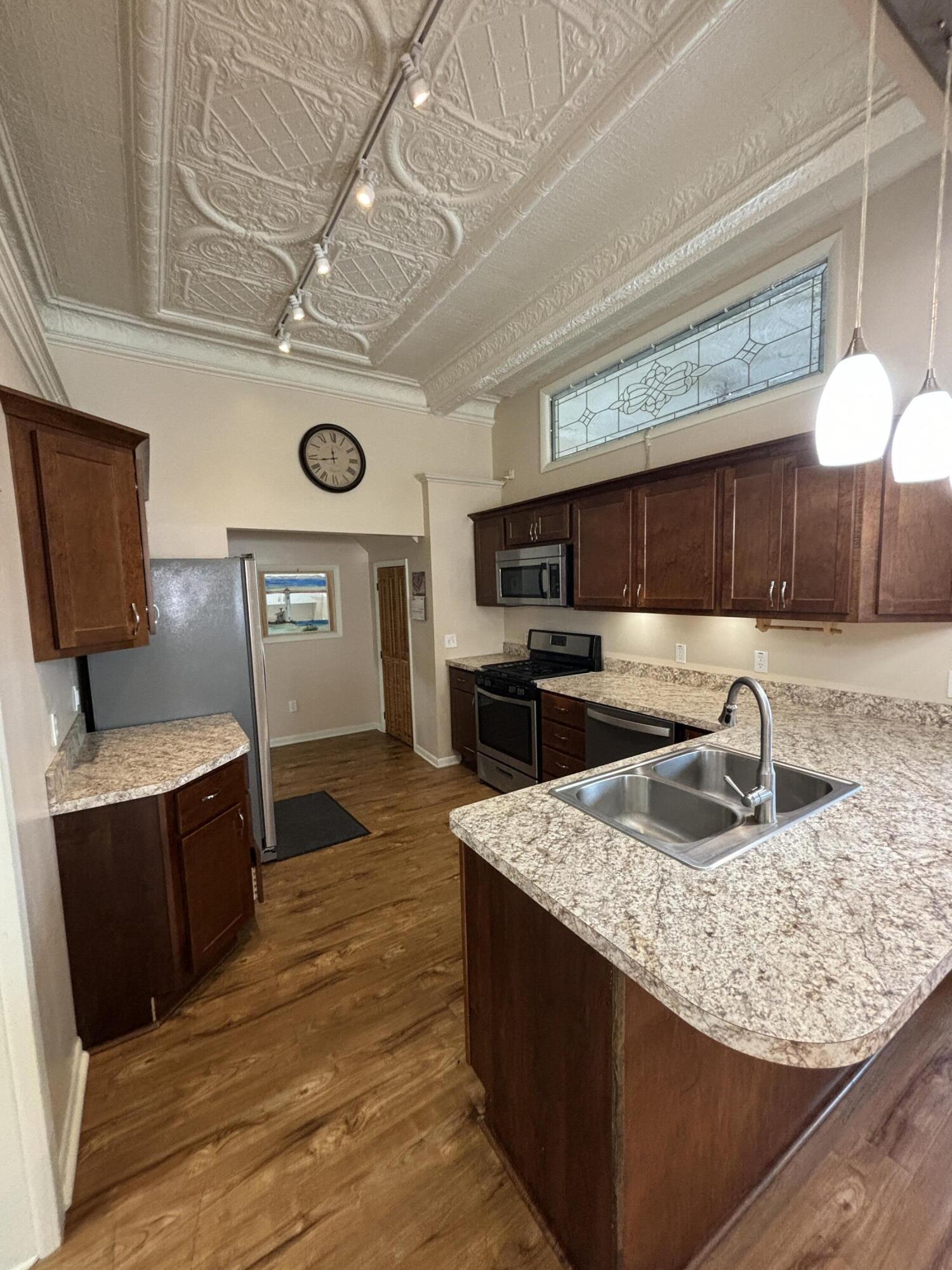 228 West Barker Avenue, Unit 1 Michigan City, IN 46360 - Photo 2 of 7 a kitchen with granite countertop a sink a counter space cabinets and stainless steel appliances