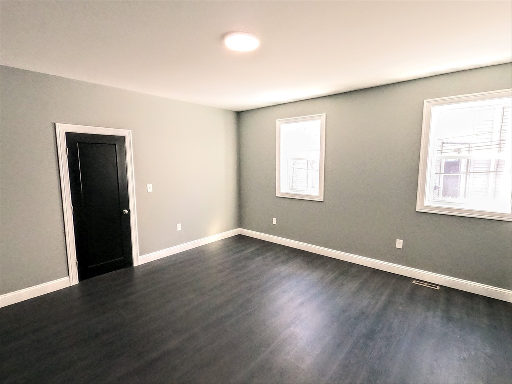 2 Sunnyside Street, Unit 1 Boston, MA 02130 - Photo 11 of 31 a view of an empty room with wooden floor and a window