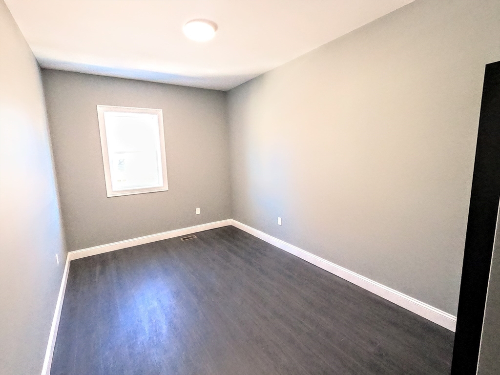 2 Sunnyside Street, Unit 1 Boston, MA 02130 - Photo 22 of 31 an empty room with wooden floor and window