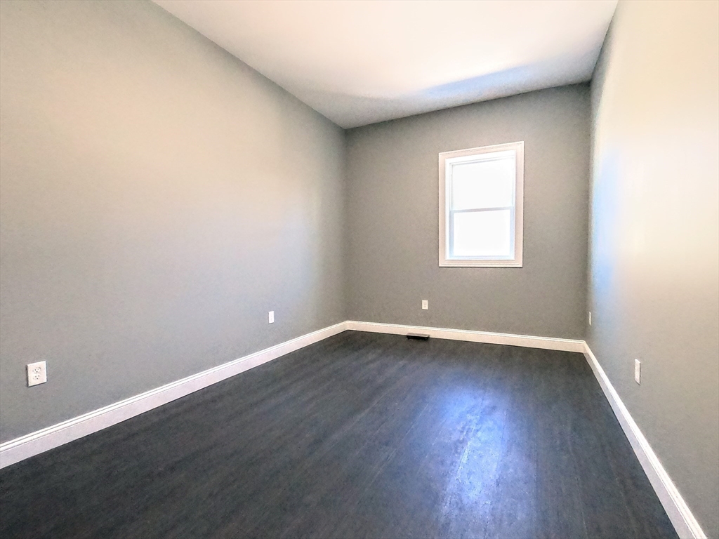 2 Sunnyside Street, Unit 1 Boston, MA 02130 - Photo 25 of 31 an empty room with wooden floor and windows