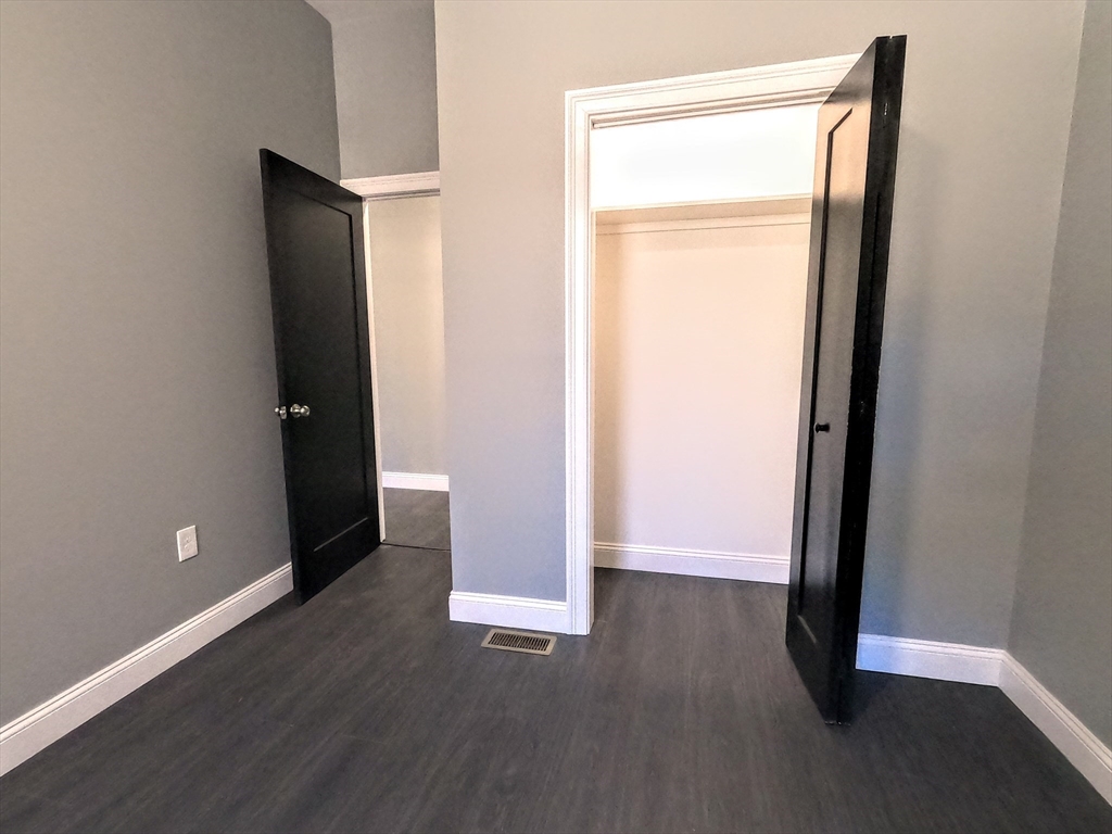 2 Sunnyside Street, Unit 1 Boston, MA 02130 - Photo 27 of 31 an empty room with wooden floor and closet