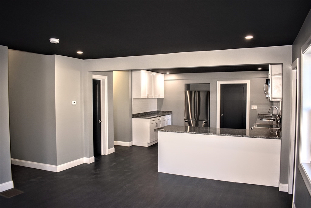 2 Sunnyside Street, Unit 1 Boston, MA 02130 - Photo 5 of 31 a view of a living room with stainless steel appliances wooden floor and a kitchen view