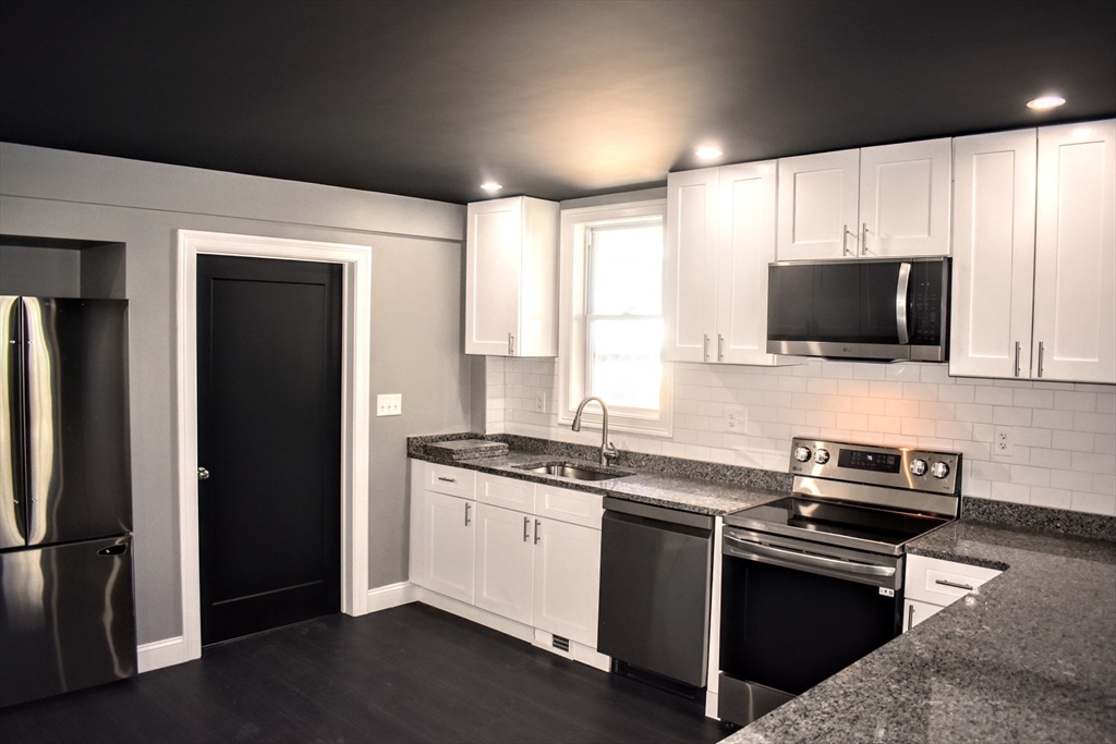 2 Sunnyside Street, Unit 1 Boston, MA 02130 - Photo 7 of 31 a kitchen with stainless steel appliances a stove a sink and a microwave