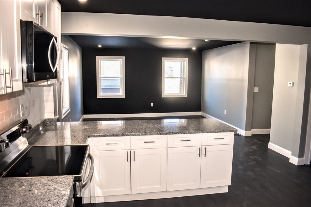 2 Sunnyside Street, Unit 1 Boston, MA 02130 - Photo 9 of 31 a bathroom with a granite countertop sink a mirror and vanity