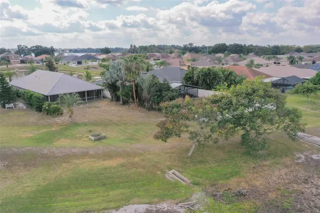 an aerial view of residential houses with outdoor space and trees