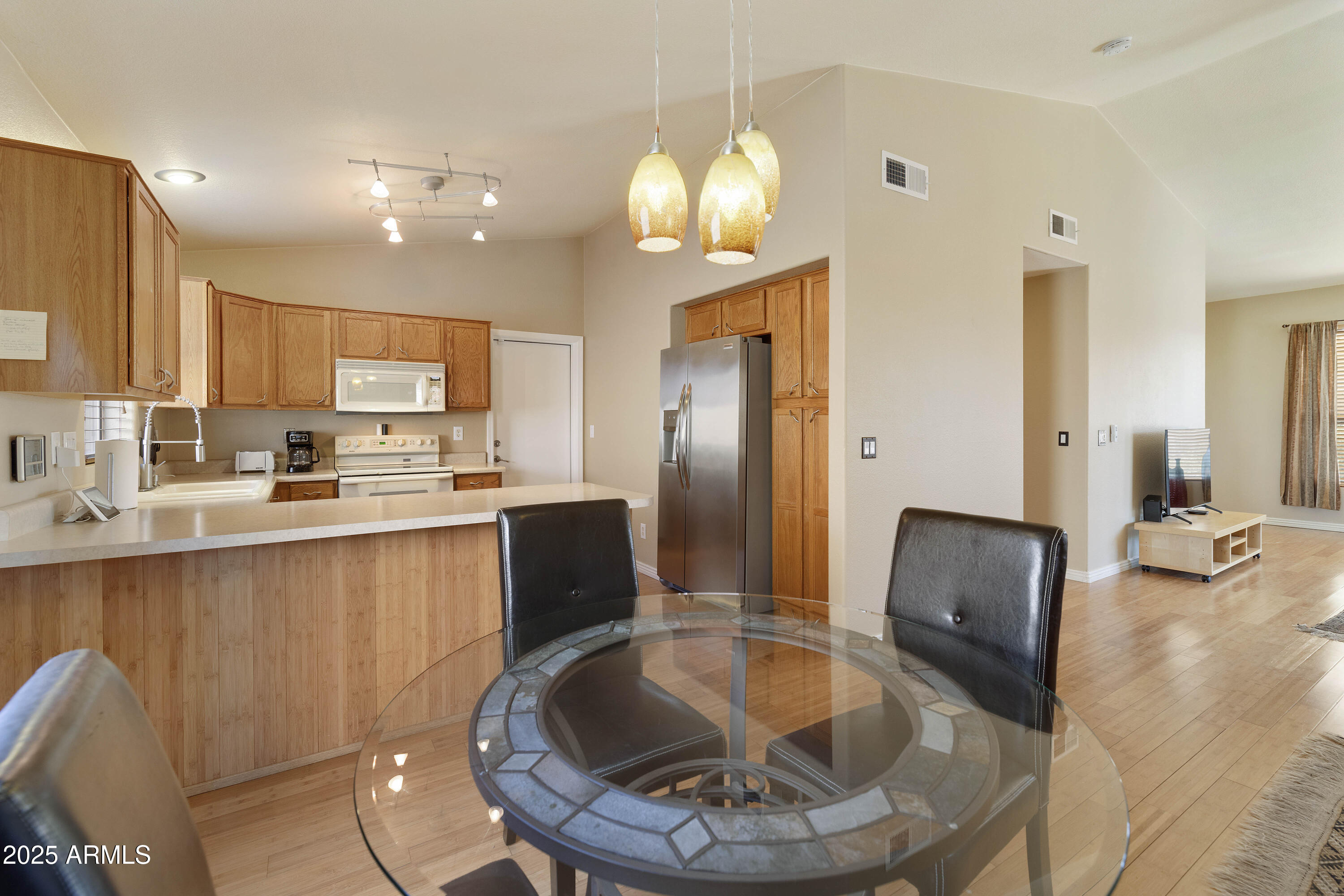 519 East Devon Drive Gilbert, AZ 85296 - Photo 37 of 47 a kitchen with stainless steel appliances granite countertop a refrigerator a stove a sink dishwasher with a dining table and chair