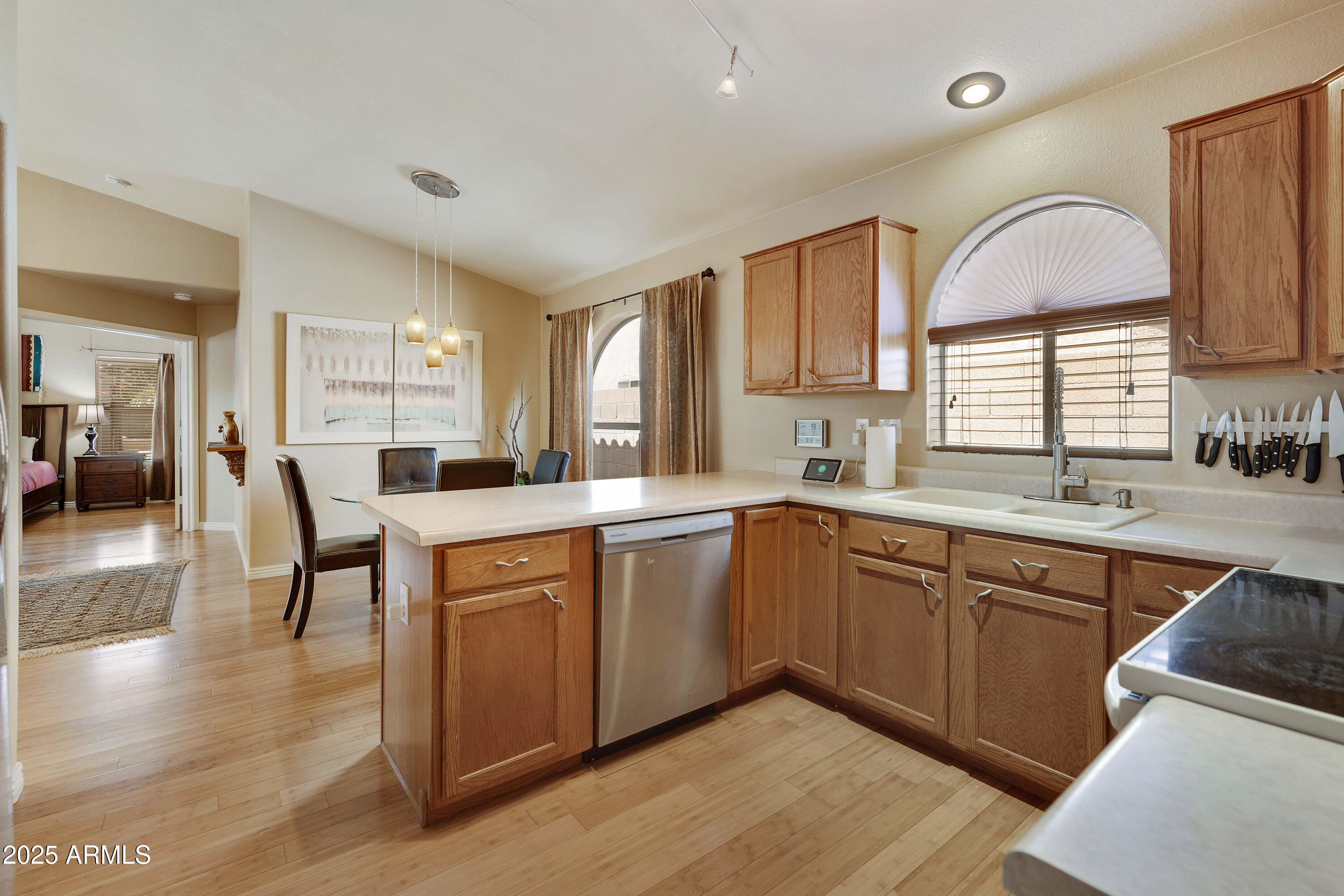 519 East Devon Drive Gilbert, AZ 85296 - Photo 40 of 47 a kitchen with stainless steel appliances granite countertop a refrigerator a sink dishwasher a dining table and chairs with wooden floor
