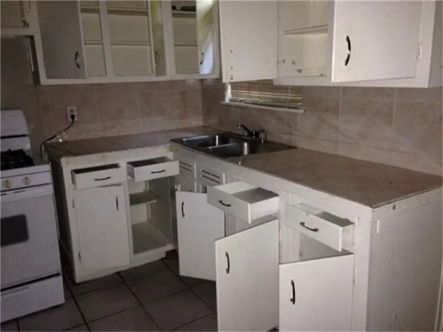 a kitchen with white cabinets and white appliances