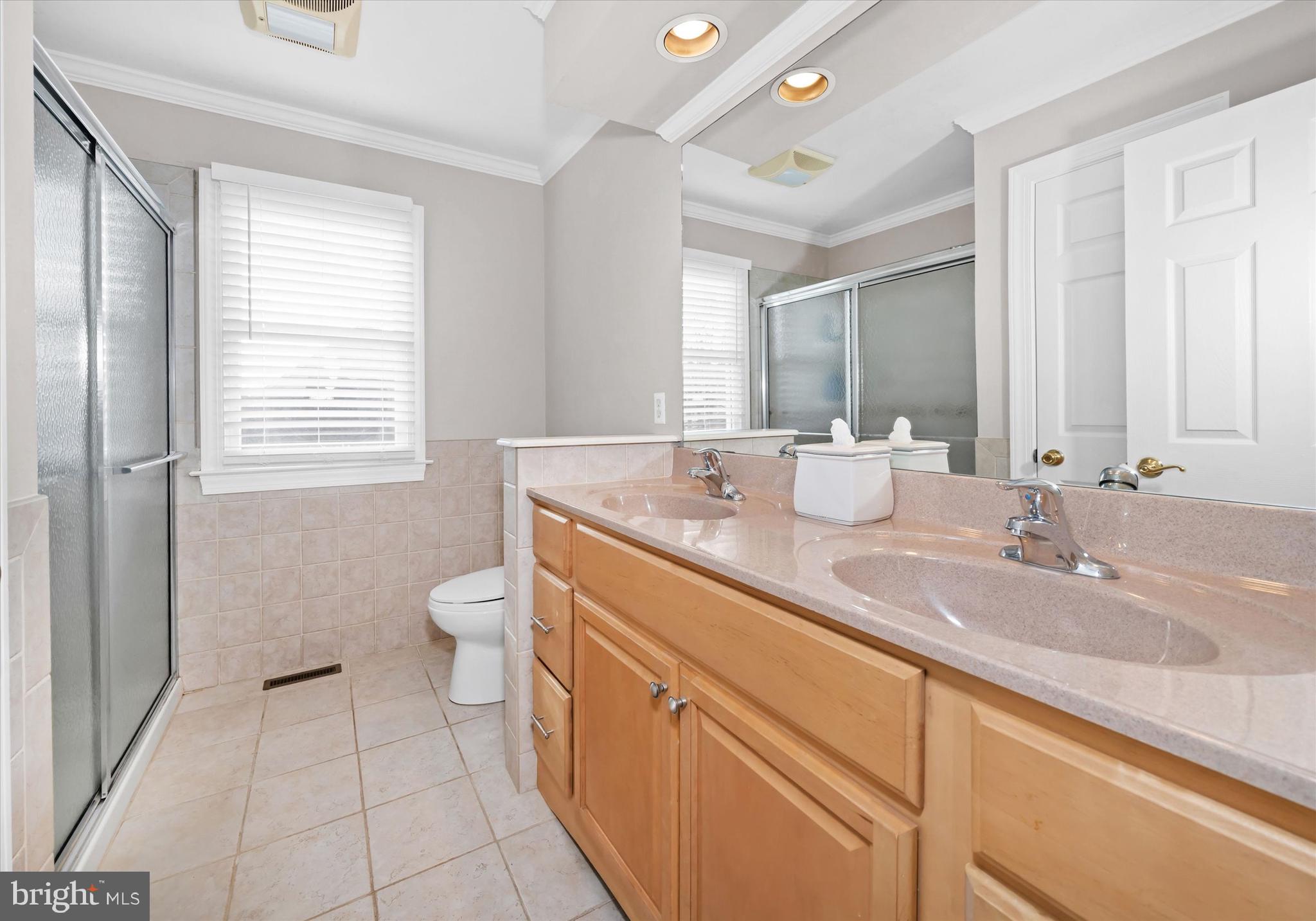 716 Regency Hill Road Hockessin, DE 19707 - Photo 51 of 73 a bathroom with a granite countertop sink a toilet a mirror and a window