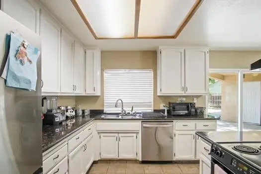 a kitchen with stainless steel appliances granite countertop a sink a stove and cabinets