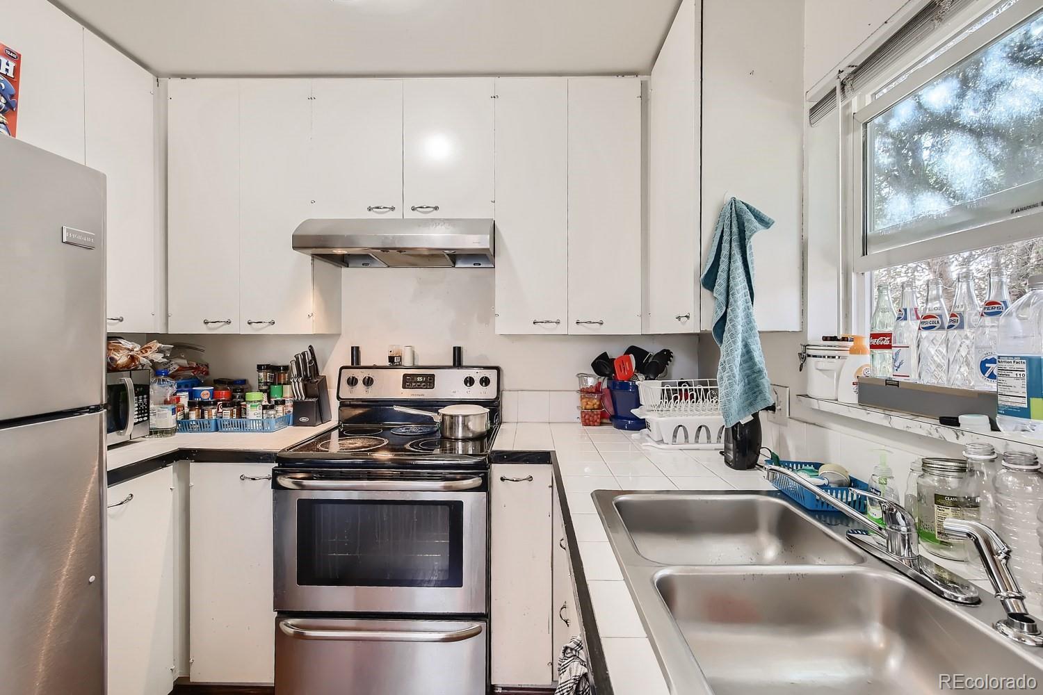 6190 Webster Street Arvada, CO 80003 - Photo 5 of 11 a kitchen with a sink a stove and a refrigerator