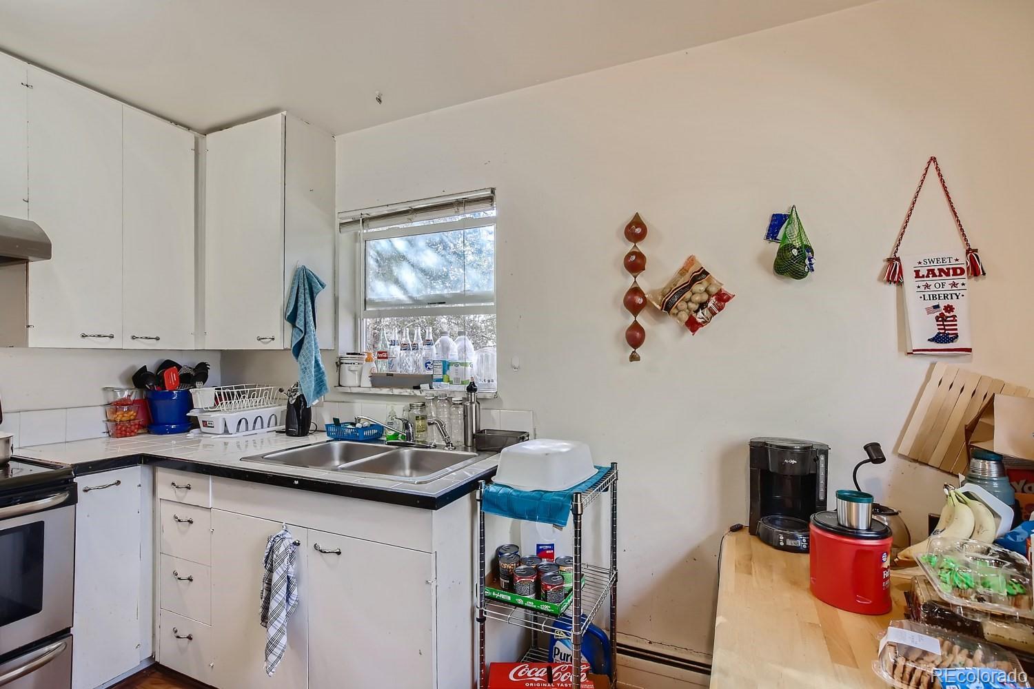 6190 Webster Street Arvada, CO 80003 - Photo 6 of 11 a kitchen with sink a microwave and cabinets