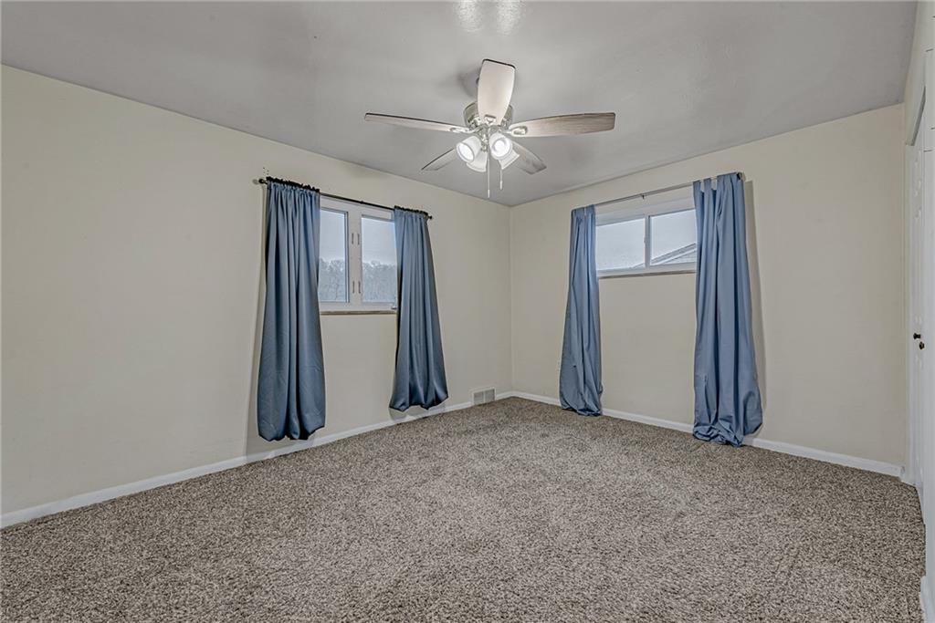 549 Filmore Road Pittsburgh, PA 15221 - Photo 11 of 25 an empty room with chandelier fan and windows