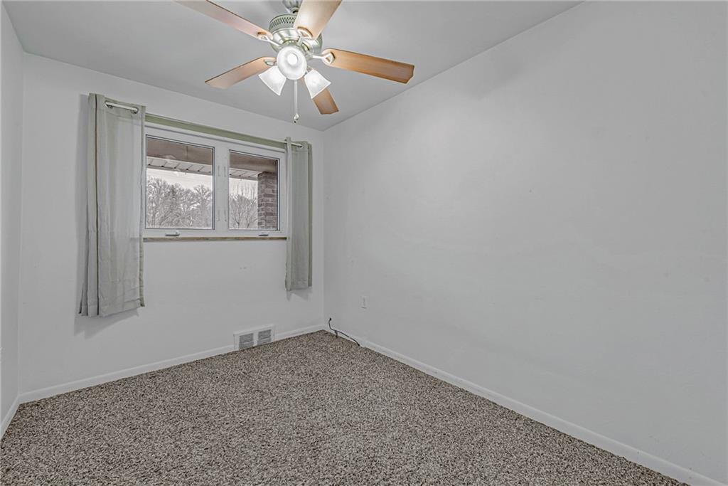 549 Filmore Road Pittsburgh, PA 15221 - Photo 16 of 25 an empty room with a chandelier fan and windows