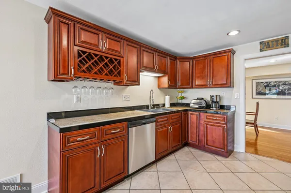 a kitchen with stainless steel appliances granite countertop wooden cabinets a sink and dishwasher