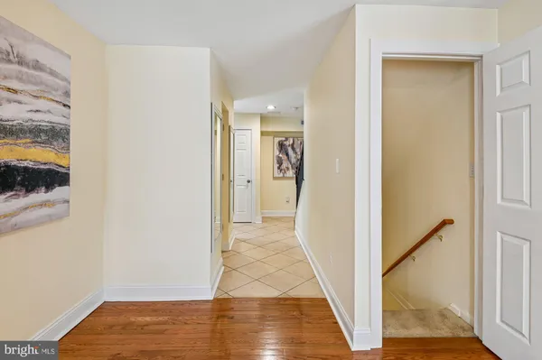 a view of a hallway with wooden floor and a living room