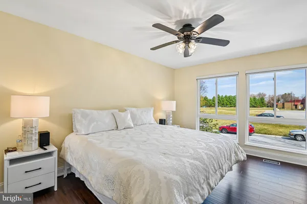 a bedroom with a bed and a large window with the outer view