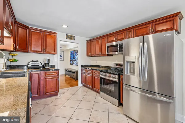 a kitchen with stainless steel appliances granite countertop a refrigerator stove top oven and sink