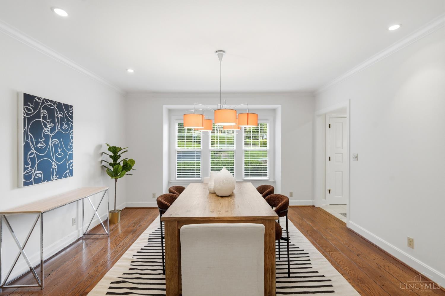 2780 Walsh Road Cincinnati, OH 45208 - Photo 25 of 77 The beautifully appointed formal dining room is designed for both everyday living and elegant entertaining. Anchored by rich hardwood floors, crown molding and a statement chandelier, the space is warm and inviting with generous proportions for hosting. Large windows bring in natural light, while seamless connectivity to adjacent living areas ensures an effortless flow for gatherings both large and small.