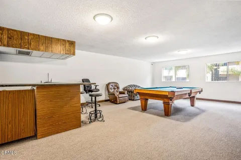 a room with furniture pool table and window