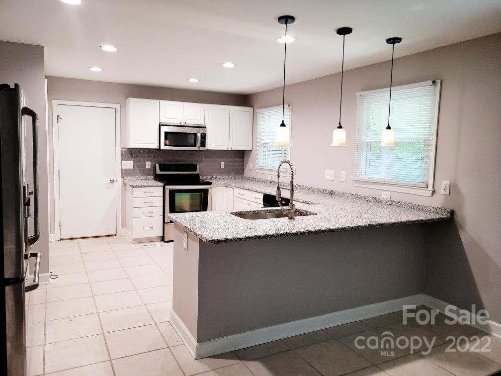 706 Fieldstone Road Mooresville, NC 28115 - Photo 3 of 11 a kitchen with stainless steel appliances granite countertop a sink a stove and a refrigerator