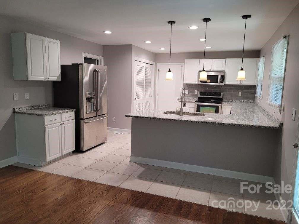 706 Fieldstone Road Mooresville, NC 28115 - Photo 4 of 11 a kitchen with kitchen island a counter space a sink appliances and cabinets