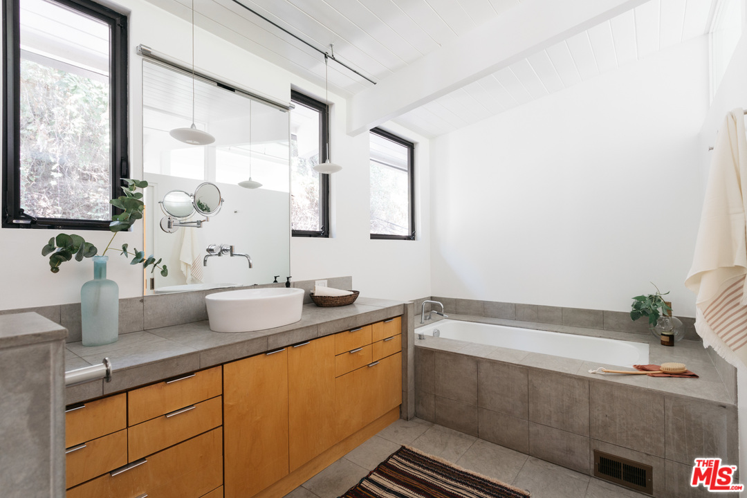 9015 Burroughs Road Los Angeles, CA 90046 - Photo 6 of 19 a bathroom with a granite countertop sink and a mirror