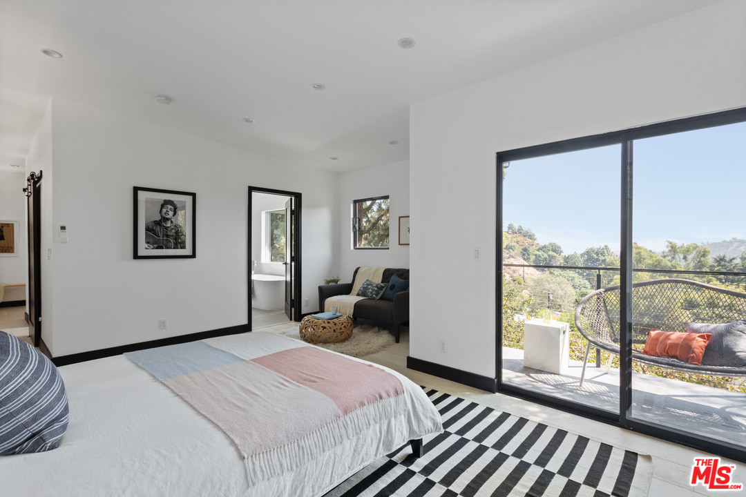9015 Burroughs Road Los Angeles, CA 90046 - Photo 9 of 19 a bedroom with a large bed and large windows