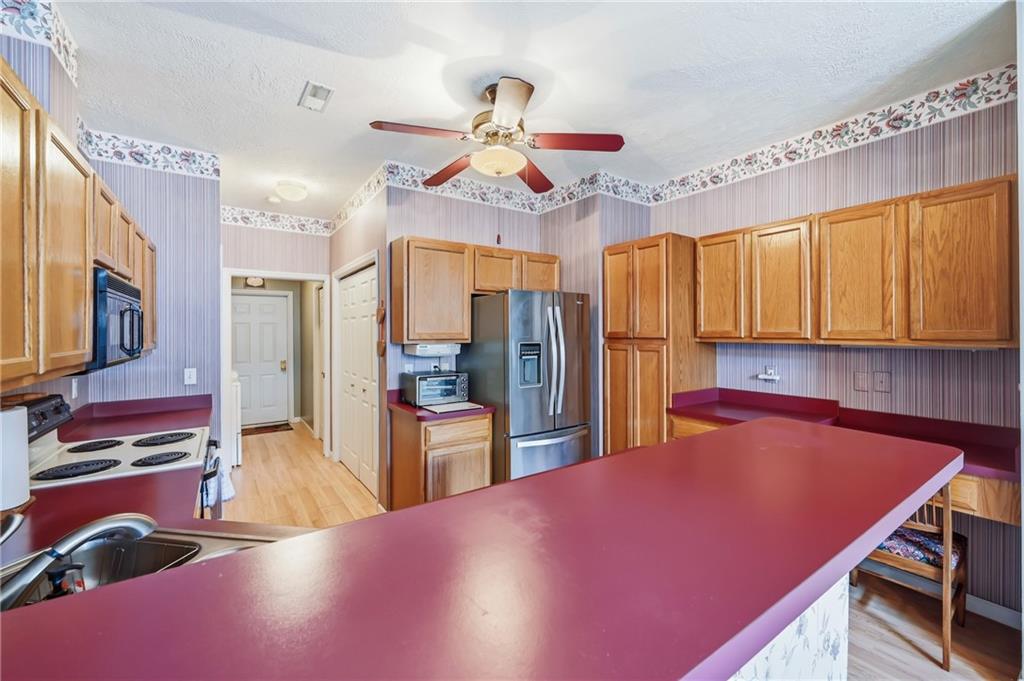 76 Stone Ridge Boulevard Hermitage, PA 16148 - Photo 17 of 34 a kitchen with stainless steel appliances kitchen island granite countertop a refrigerator a stove and a sink with wooden floor