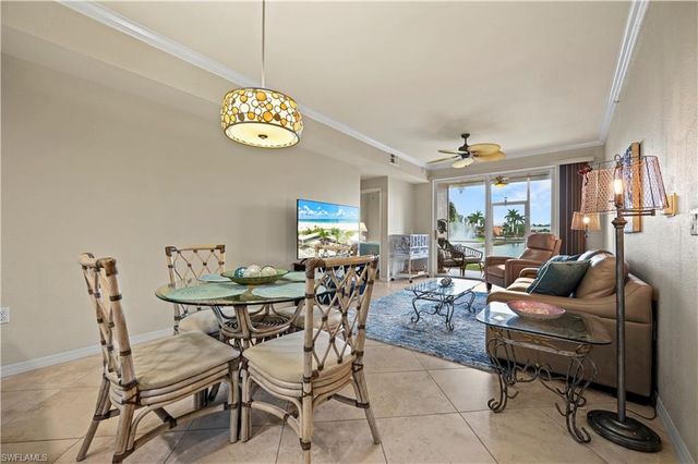 a living room with furniture a dining table and a chandelier